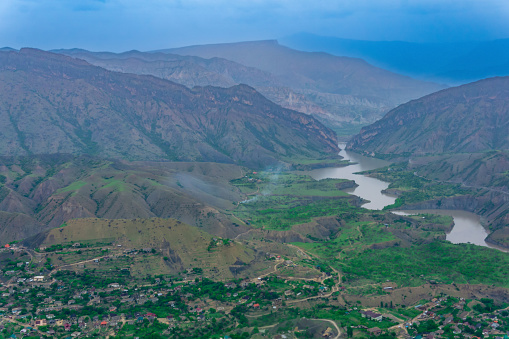 foggy mountain valley with river, villages and fields