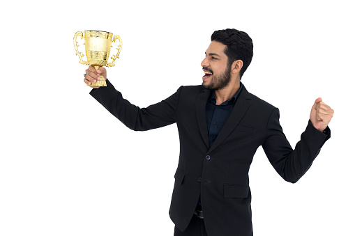 Young wavy hair, moustache and beard businessman in black suit looking at the trophy received from the work done proudly. Portrait on white background with studio light.