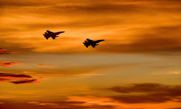 ビルの街並み美しいオレンジ色の夕焼けの空の背景を持つシルエットの飛行機。 - air force military us military armed forces ストックフォトと画像