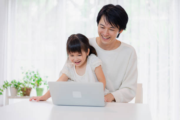 istock Little girl using the computer with her father 1406296786