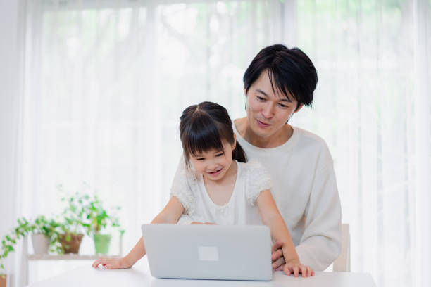 istock Little girl using the computer with her father 1406296797