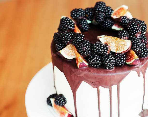 istock A gourmet cake drenched in chocolate and garnished with blackberries and figs. 1406301528