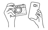 istock Hands Holding a Camera and smartphone. Hand drawing illustration. 1406302333