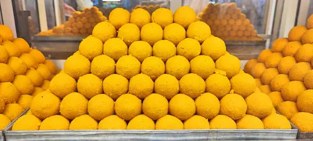 Indian festival sweet - Besan Laddu, made with gram flour, sugar and ghee, placed in a show case.