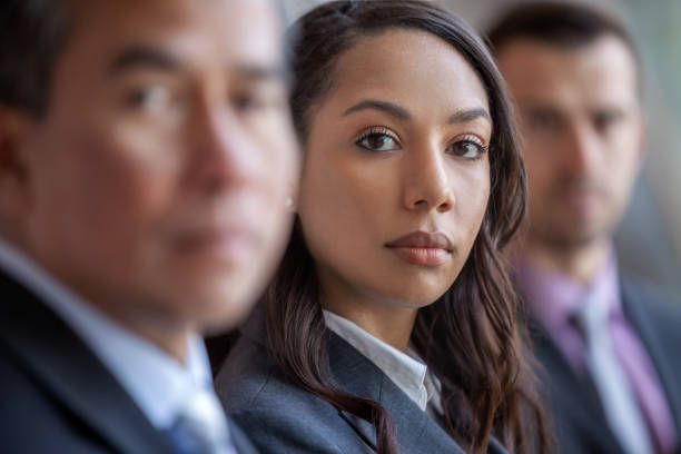 portrait of young multiracial black businesswoman sitting in meeting with colleagues in a row - serious african ethnicity mid adult bright imagens e fotografias de stock