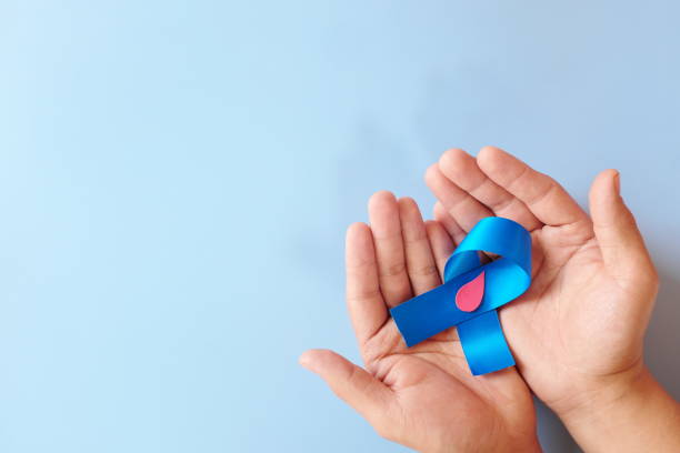 赤い血の滴とコピースペースを持つ青いリボンを持つ手の上面図。世界糖尿病の日のコンセプト。 - social awareness symbol ストックフォトと画像
