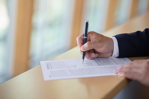Businessman signing document with pen close-up