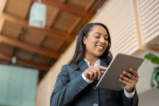 Portrait of multiracial African American Black businesswoman using internet with digital tablet low angle view