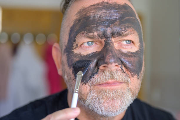 istock Middle-aged man applying a face mask in a skin care concept 1406314495