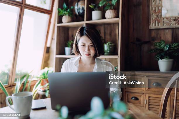 Young Asian Female Freelancer Working Online On Laptop Computer From Home Office Businesswoman Entrepreneur Blogger Freelancer Working From Home Concepts In Cozy Atmosphere Lifestyle And Technology Stock Photo - Download Image Now