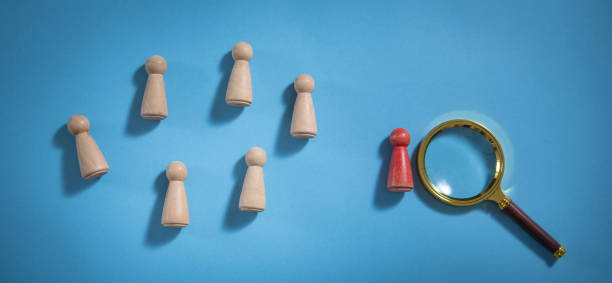 istock Magnifying glass and wooden human figures. 1406318469