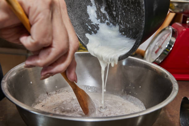istock Chef pours whipped cream into a chocolate cake mix with pears and nuts. Step by step recipe 1406318650