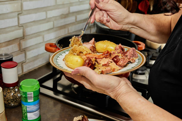 istock Chef puts the finished Alsatian sauerkraut on serving plate 1406318703