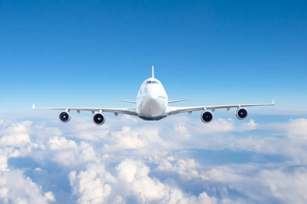 istock Airplane travel flying in the sky, looking directly at the liner with four engines. 1406319528