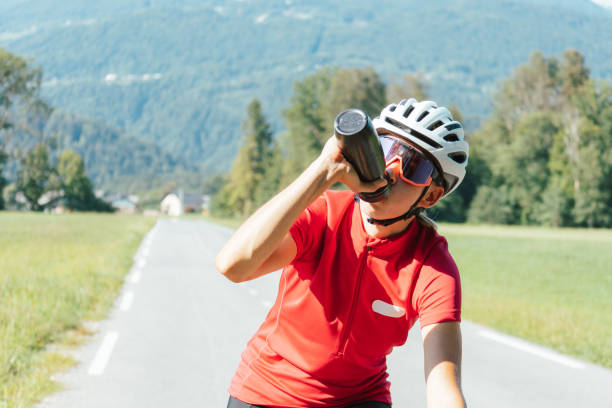 istock Female road cyclist keeping hydrated during a ride 1406319597