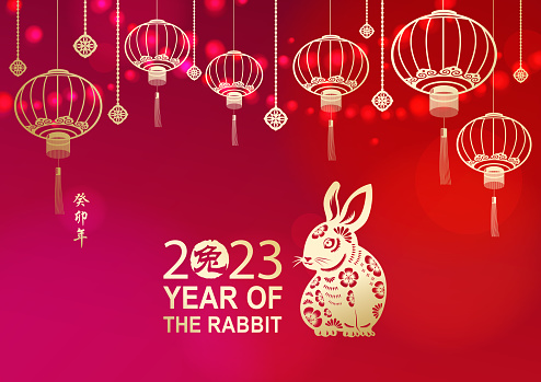 Celebrate the Year of the Rabbit 2023 with lights and gold colored Chinese lanterns and rabbit on the red background, the Chinese stamp means rabbit and the vertical Chinese phrase means Year of the Rabbit according to lunar calendar system