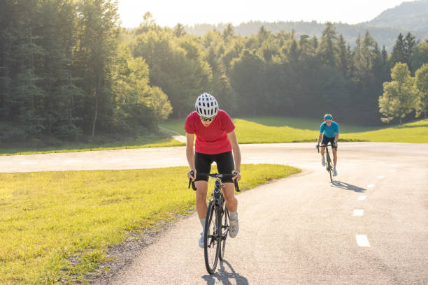 istock Female athlete on a racing bicycle riding uphill 1406319664