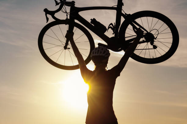 istock Racing female cyclist raising bicycle with both arms above her head 1406319673