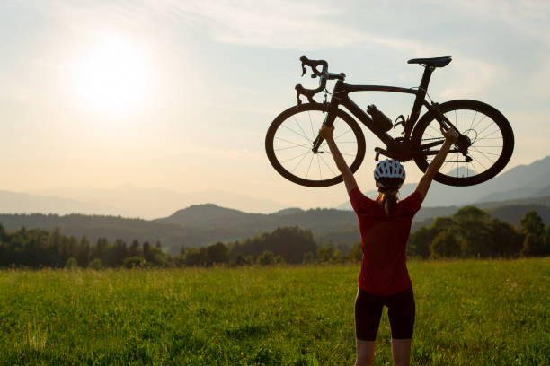 istock Racing female cyclist raising bicycle with both arms above her head 1406319713