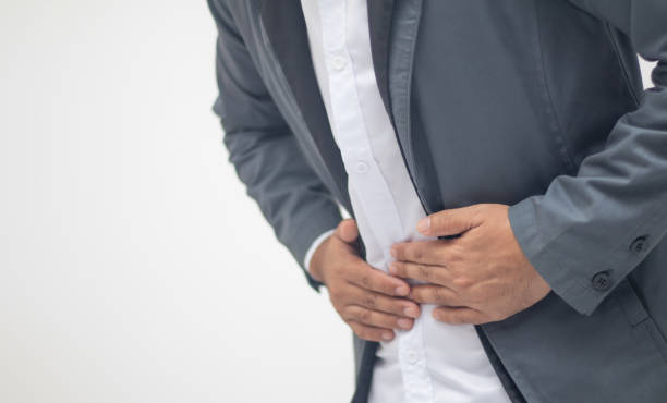 istock A working man puts his hand on his stomach due to pain. 1406321747