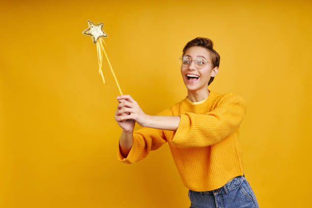 istock Playful young woman holding magic wand 1406325111