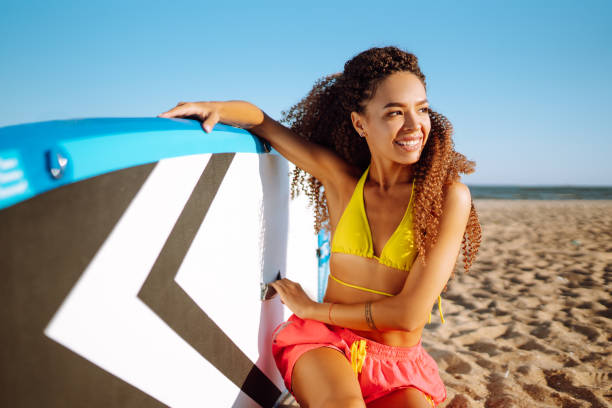 istock Woman surfer walks with a board on the sandy beach. 1406326223