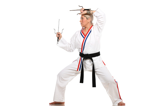 One young woman and one young man, karate students, training karate together in gym.