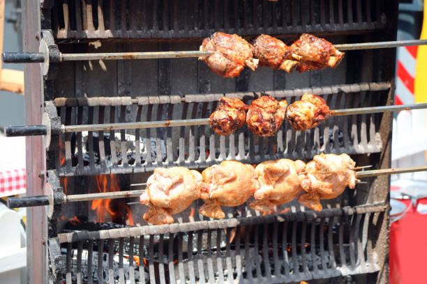 Barbecuing chicken on a giant outdoor rotisserie at the fair