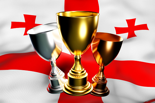 3d illustration of a cup of gold, silver and bronze winners on the background of the national flag of Georgia. 3D visualization of an award for sporting achievements