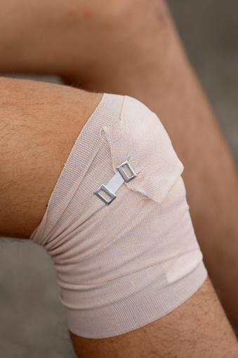 boy's knee after the sprain with an elastic band for protection of the damaged joint