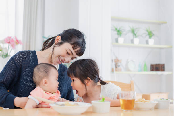 赤ちゃんの世話をする子供 - baby eating child mother ストックフォトと画像