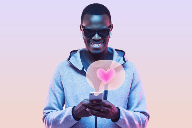 istock African man liking posts on social network pages, standing against studio background in neon light 1406332030