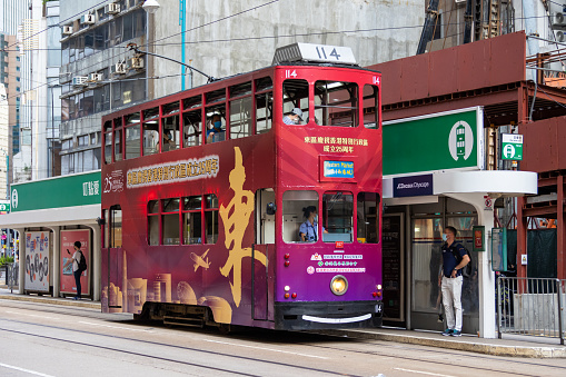 Hong Kong - June 29, 2022 : A tram featuring an advertisement celebrating the 25th anniversary of Hong Kong's handover from Britain to China, in Sheung Wan, Hong Kong.