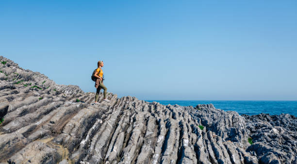 istock Woman with backpack walking through flysch rock landscape 1406332511