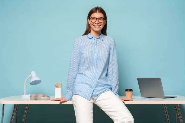istock Corporate HR manager teaching lesson to staff members sitting on table in white jeans 1406335611