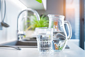 Glass of water and jug on kitchen counter