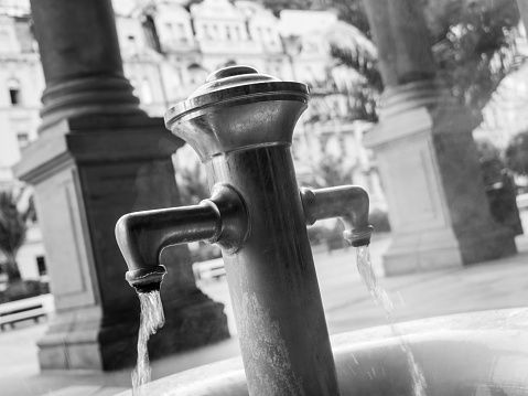 Drinking fountain in a public urban space on a sidewalk with cobblestone with nobody around