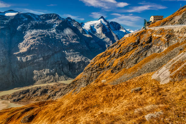 High Alpine landscape of the rocky ranges of the Austrian Alps turned into autumn colors with the Grossglockner peak in the background.