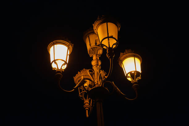 istock A large, broken street lamp against a dark sky. 1406340311