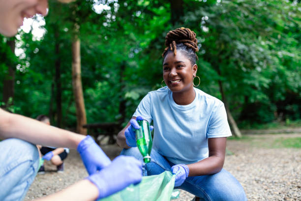 un groupe multiethnique de personnes, nettoyant ensemble dans un parc public, protège l’environnement. le concept de recyclage et de nettoyage - dépollution photos et images de collection