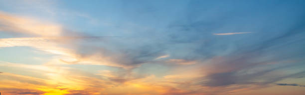 The sky at sunset or sunrise with orange clouds and a blue tint stock photo