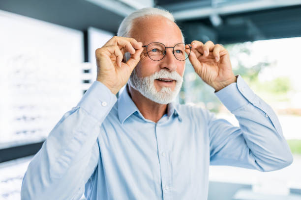 istock Senior man trying on eyeglasses to buy 1406351488