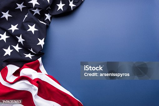 istock The flag of the United States of America on blue background with copy space 1406351653