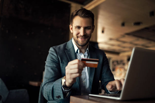 istock Businessman using laptop holding credit card while online shopping 1406352644