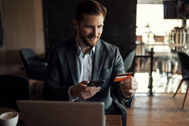 istock Businessman holding credit card while shopping online 1406352685