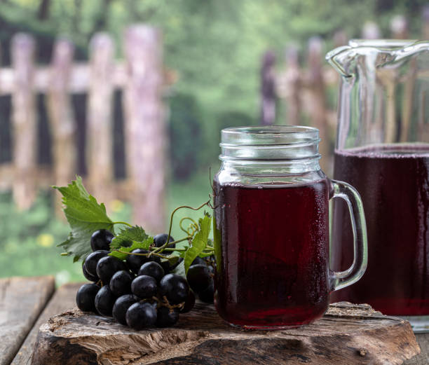 istock Glass and pitcher of grape juice with fresh grapes 1406352892