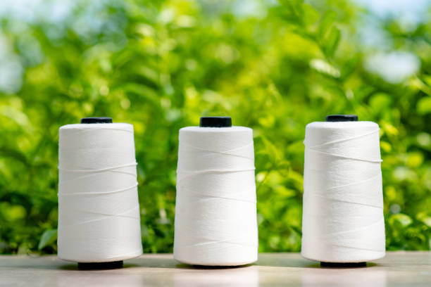 Textile factory. Equipment with spools of white yarn