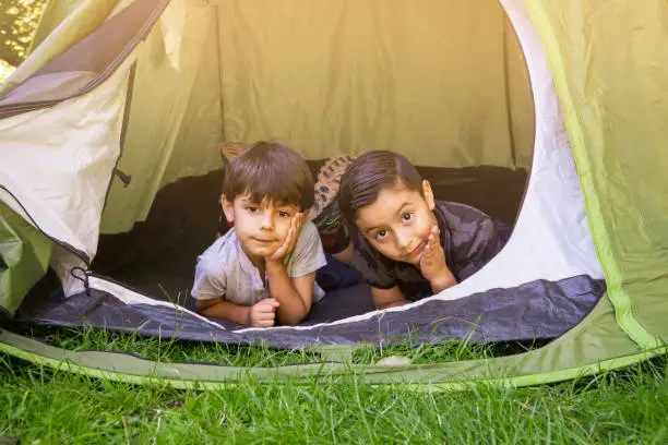 Children inside a camping tent on a summercamp. Holidays concept, nature living.