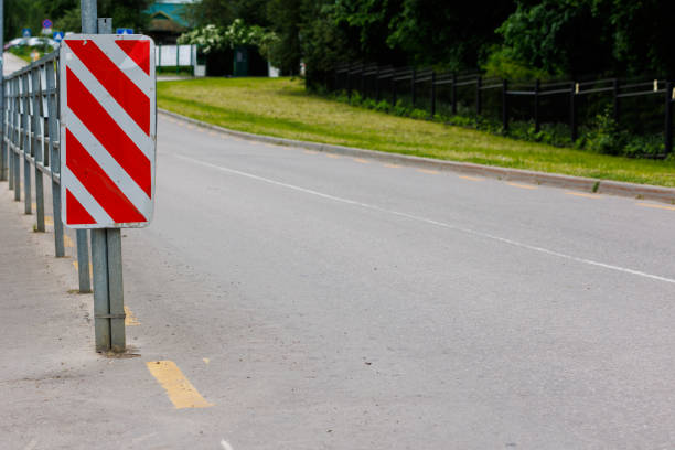 warning red and white diagonal striped vertical marking 8.22.2 sign at the end of road fence, separating road and