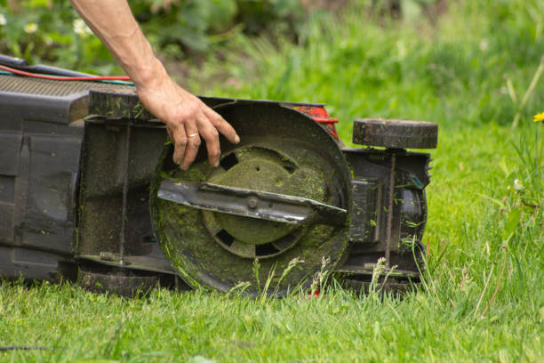 istock the lawn mower lies on its side and adjusts the with its hand 1406355961